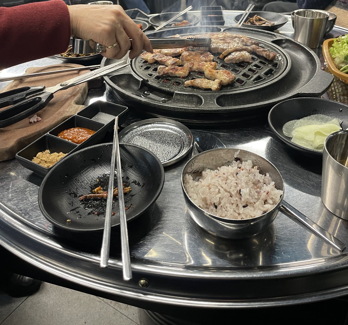 炭火の丸い鉄板で焼く韓国の焼肉と雑穀ごはん