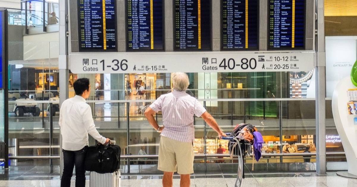 空港の案内板でフライト情報を確認する