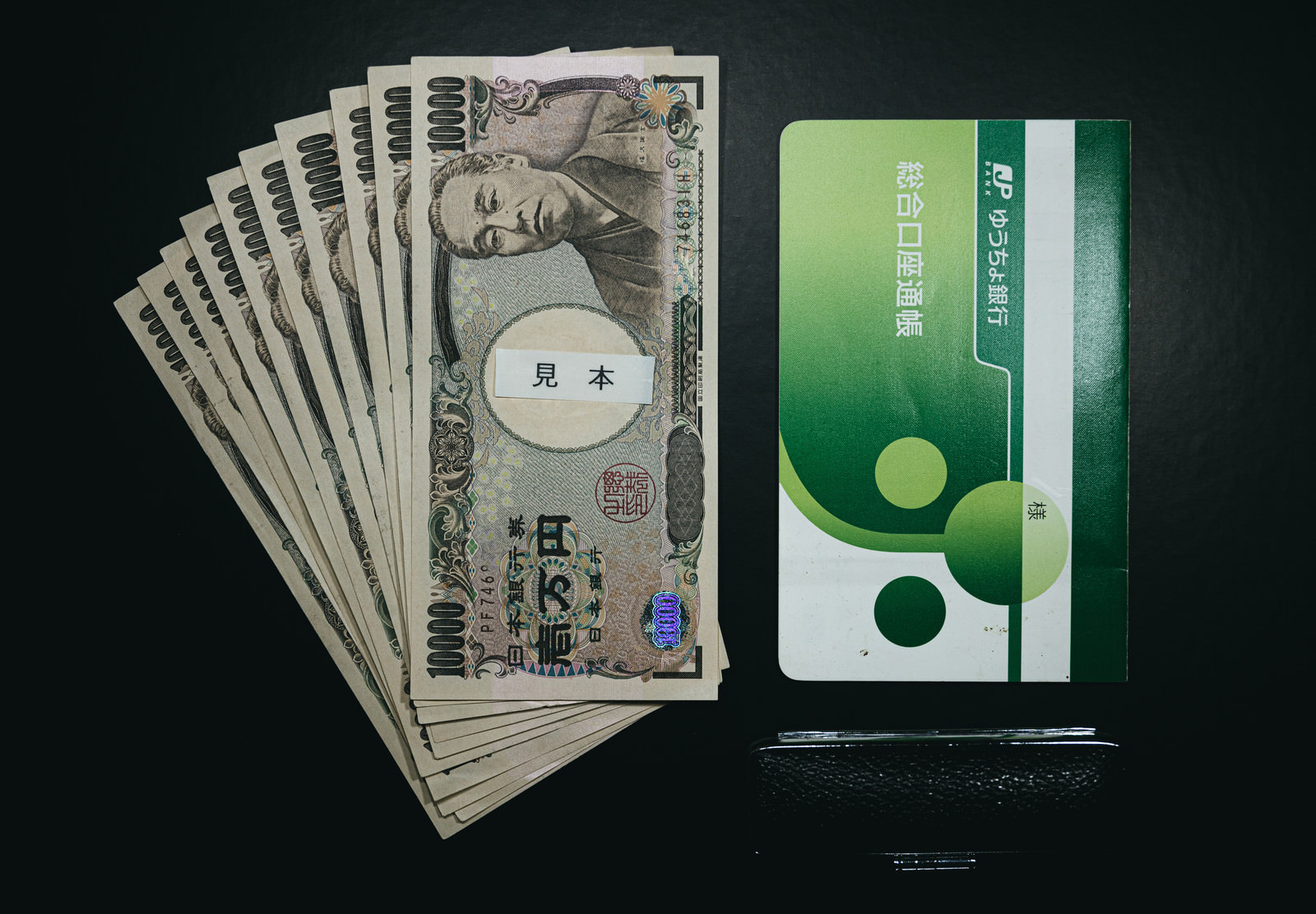 現金と銀行の通帳、印鑑が並んだ様子