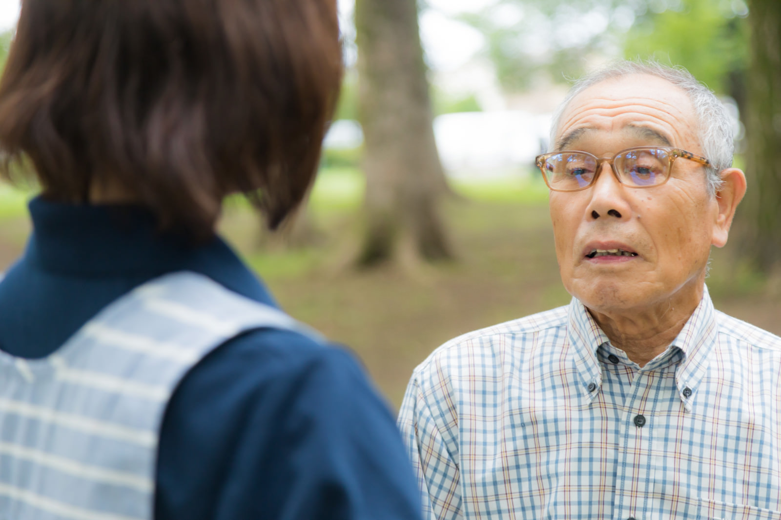 介護士と高齢男性が向かい合って会話する様子