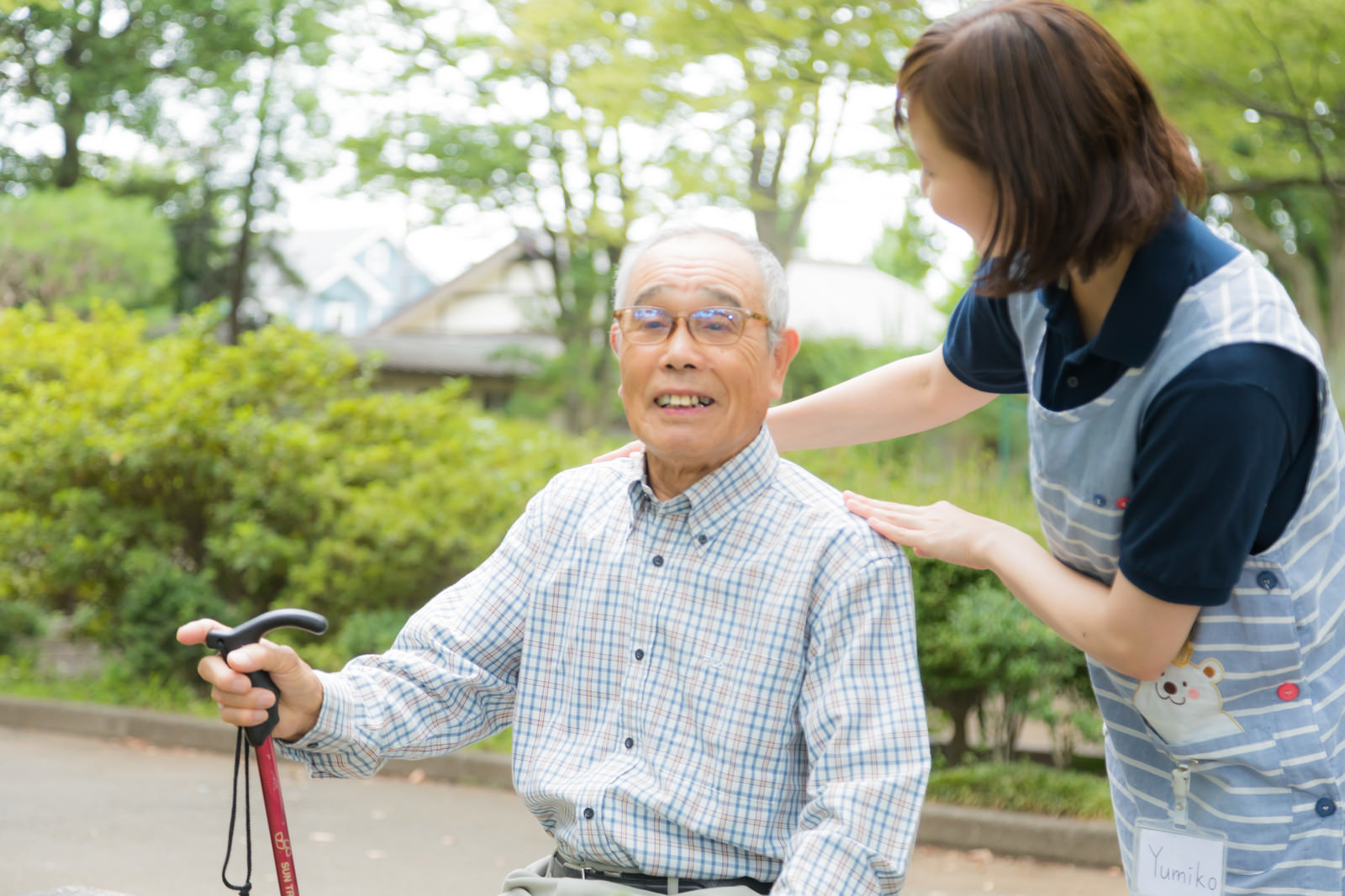 公園で過ごす高齢男性と介護士の女性