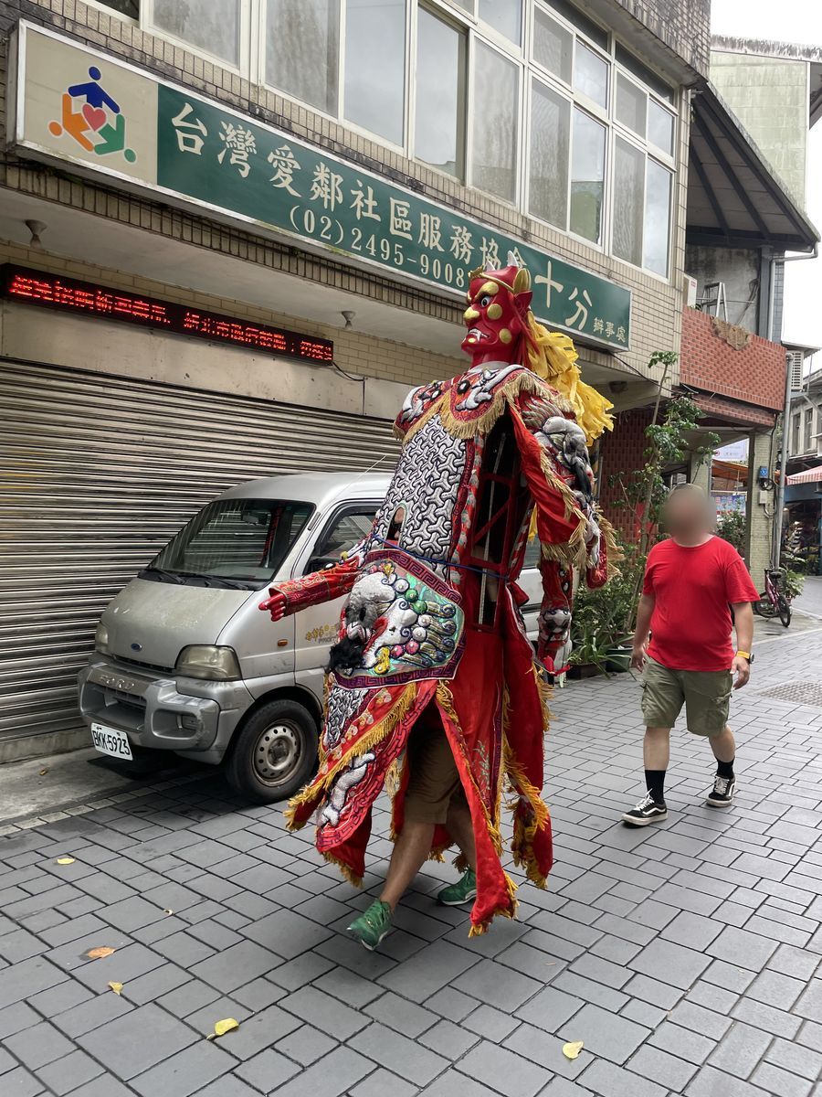 神様の衣装で十分の老街を歩く人